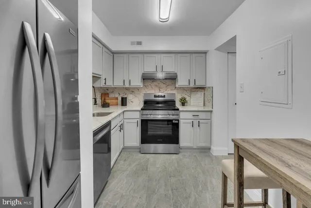 a kitchen with stainless steel appliances granite countertop a refrigerator stove and sink