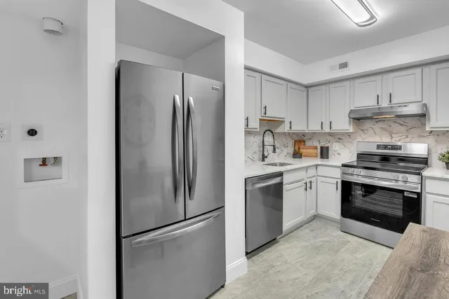 a kitchen with stainless steel appliances granite countertop a refrigerator stove and sink