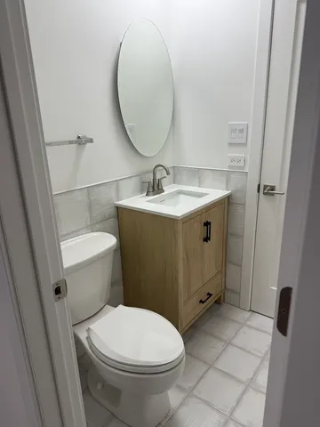 a bathroom with a granite countertop toilet sink and mirror
