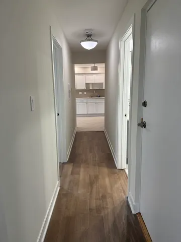 a view of a hallway with wooden floor and a window