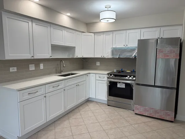 a kitchen with white cabinets and stainless steel appliances