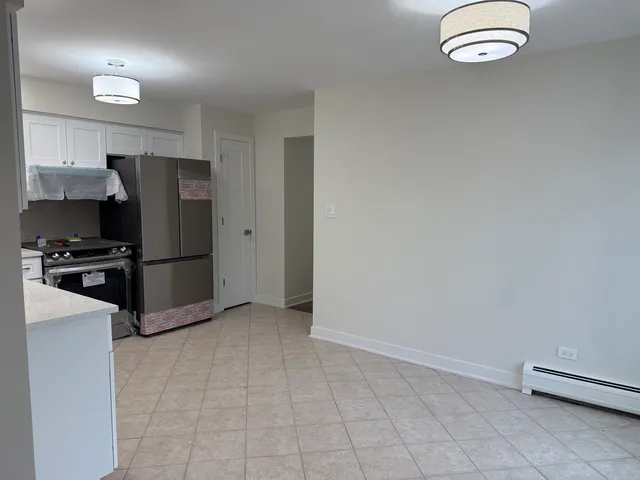 a kitchen with granite countertop a refrigerator and a stove top oven