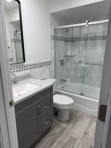 a bathroom with a double vanity sink toilet and shower