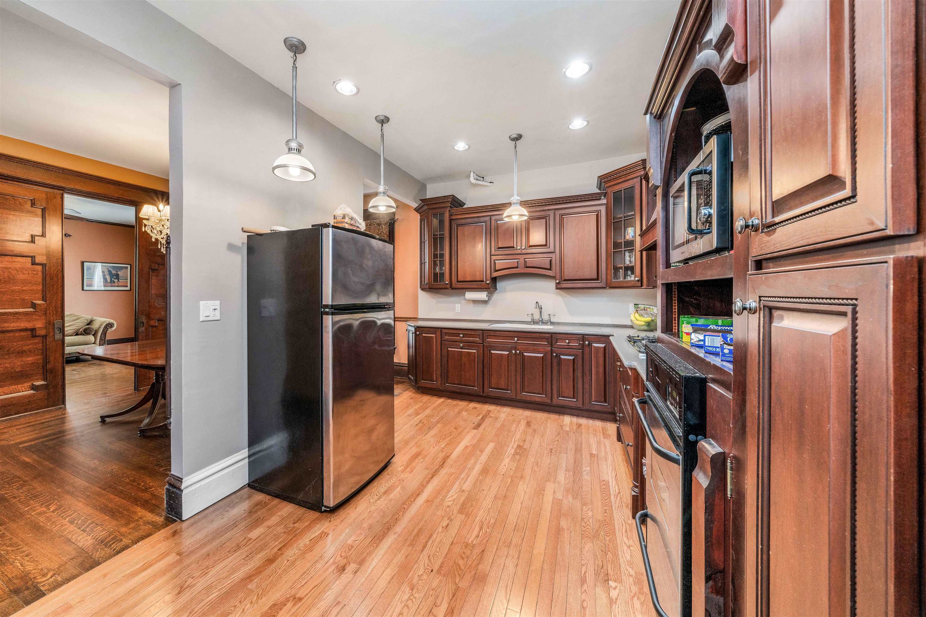 111 South Sycamore Street Genoa, IL 60135 - Photo 11 of 22 a kitchen with stainless steel appliances a refrigerator and a wooden floor