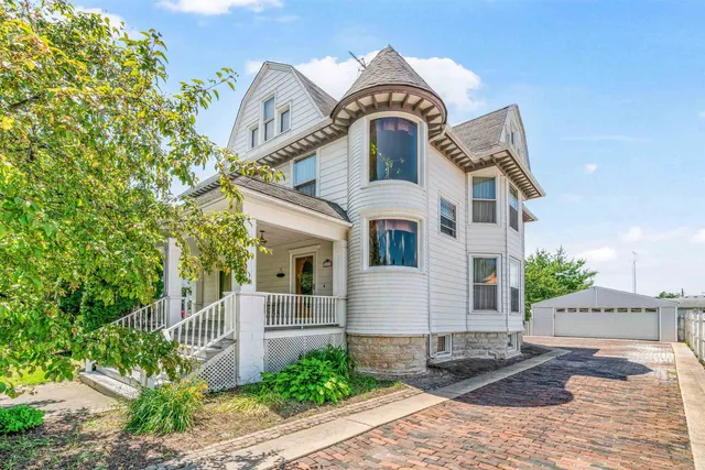 a view of a white house with large windows and a tree