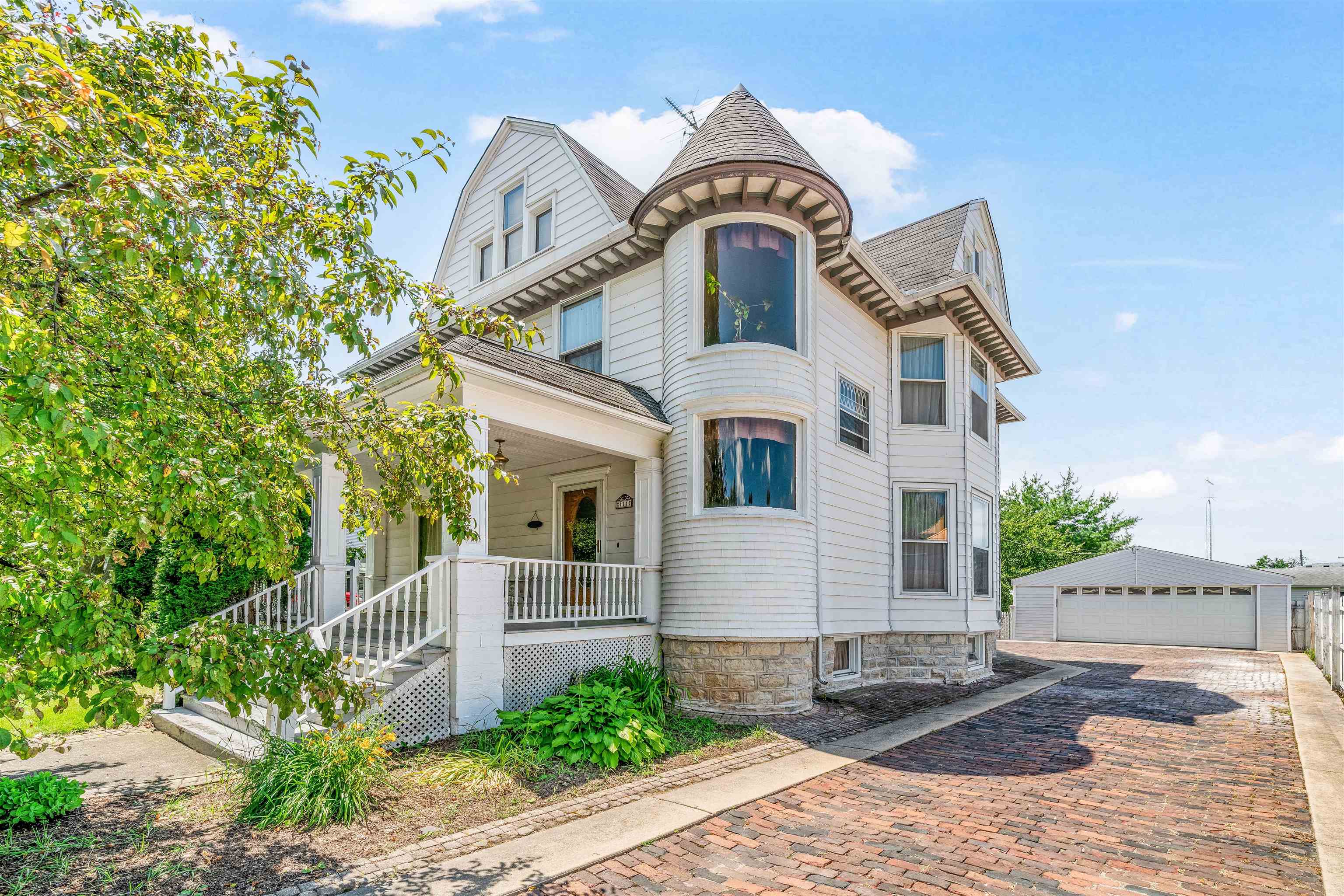 111 South Sycamore Street Genoa, IL 60135 - Photo 15 of 22 a view of a white house with large windows and a tree
