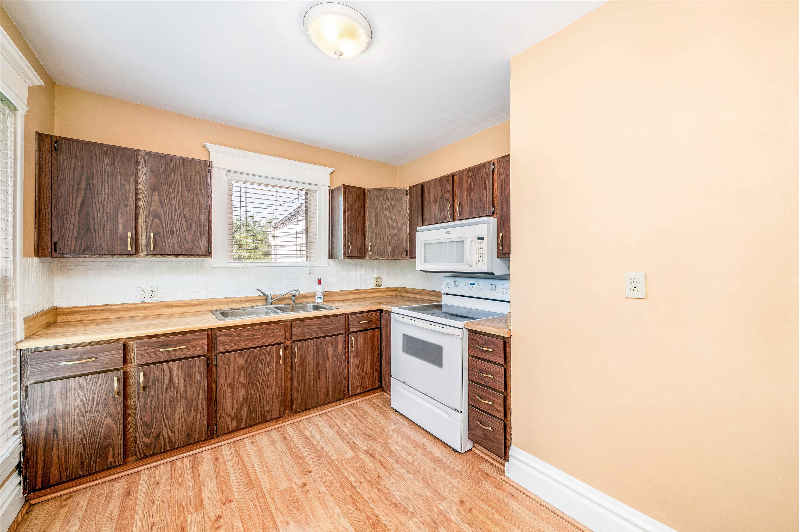 111 South Sycamore Street Genoa, IL 60135 - Photo 7 of 22 a kitchen with stainless steel appliances granite countertop a sink stove and cabinets