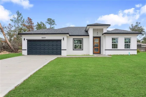 a front view of a house with a garden and yard