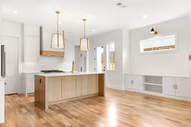 a kitchen with stainless steel appliances granite countertop a sink a stove and a wooden floors