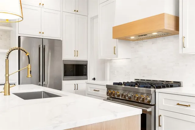 a kitchen with stainless steel appliances a stove a sink and a refrigerator