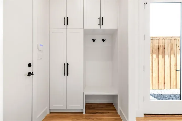a hallway with wooden floor electronic appliances and window