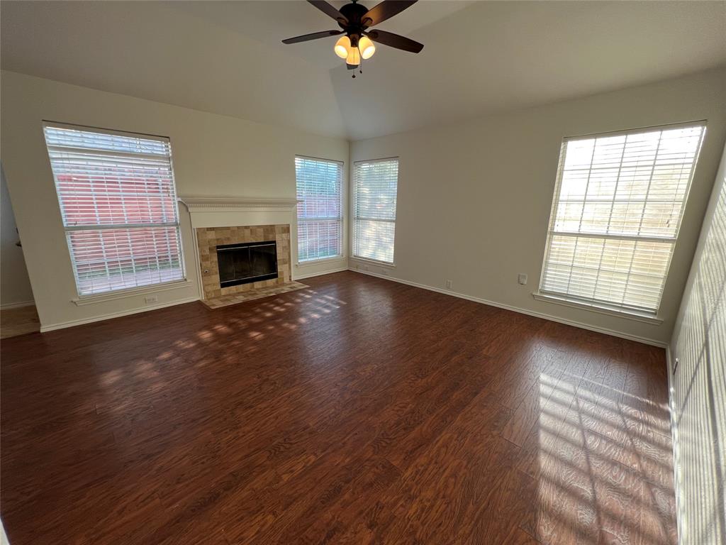 334 Touchdown Drive Irving, TX 75063 - Photo 26 of 32 Spacious living area featuring wood-finish flooring, a ceiling fan, and multiple windows with blinds