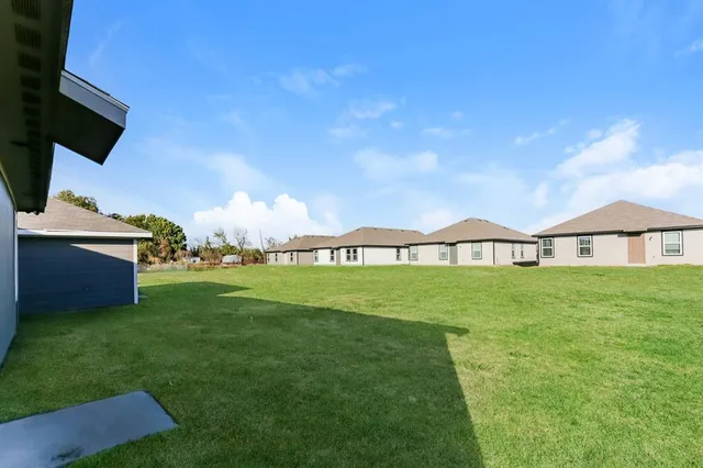 a view of yard with swimming pool and green space