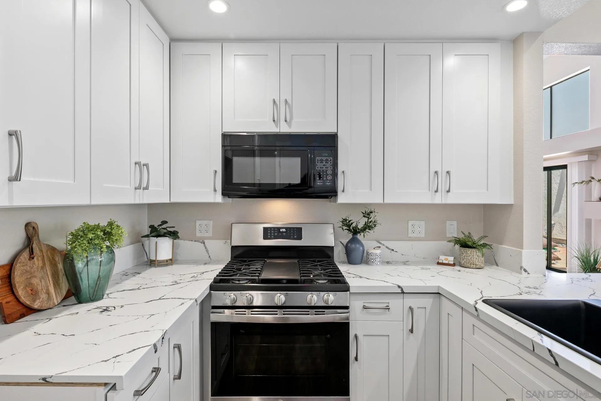 802 Spindrift Lane Carlsbad, CA 92011 - Photo 4 of 31 a kitchen with granite countertop white cabinets and a stove