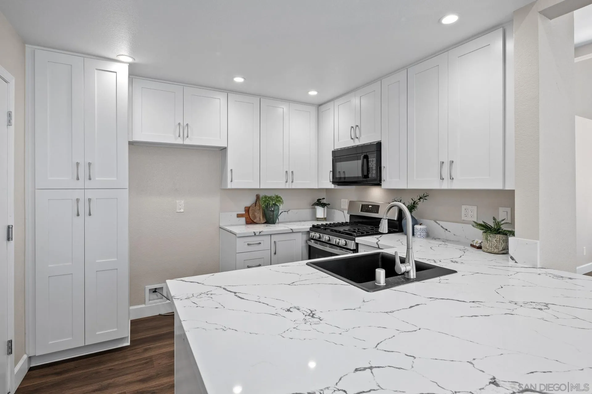 802 Spindrift Lane Carlsbad, CA 92011 - Photo 8 of 31 a kitchen with sink a microwave and cabinets