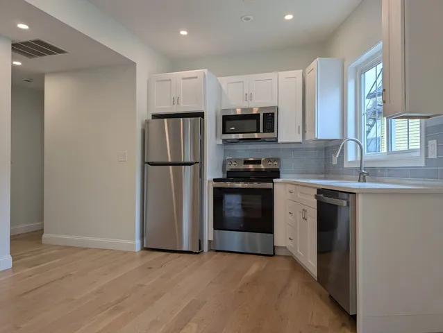 a kitchen with stainless steel appliances a refrigerator sink and microwave