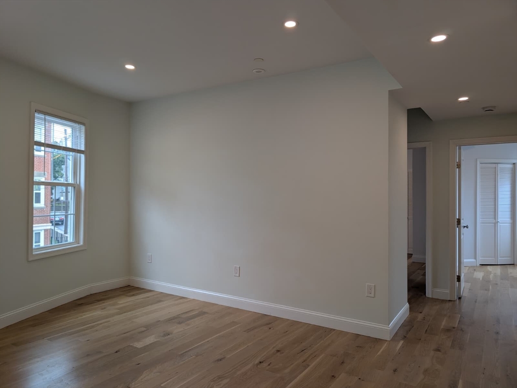 38 Regent Street, Unit 2 Boston, MA 02119 - Photo 3 of 14 an empty room with wooden floor and windows