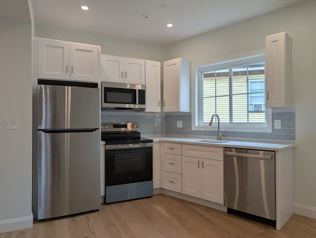 a kitchen with a white cabinets and stainless steel appliances