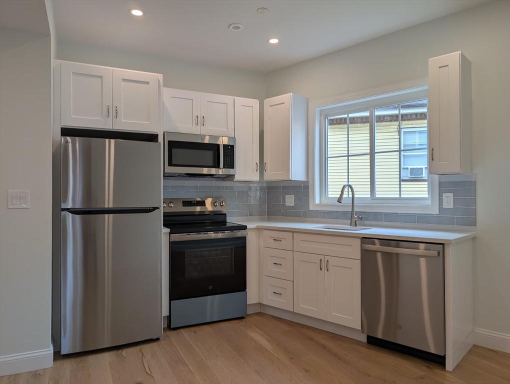 38 Regent Street, Unit 2 Boston, MA 02119 - Photo 4 of 14 a kitchen with a white cabinets and stainless steel appliances