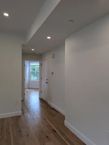 a view of a hallway with wooden floor