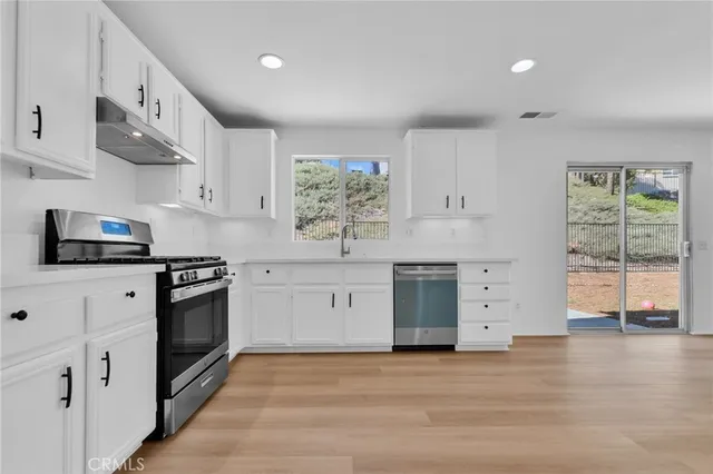 a kitchen with stainless steel appliances a stove sink and cabinets