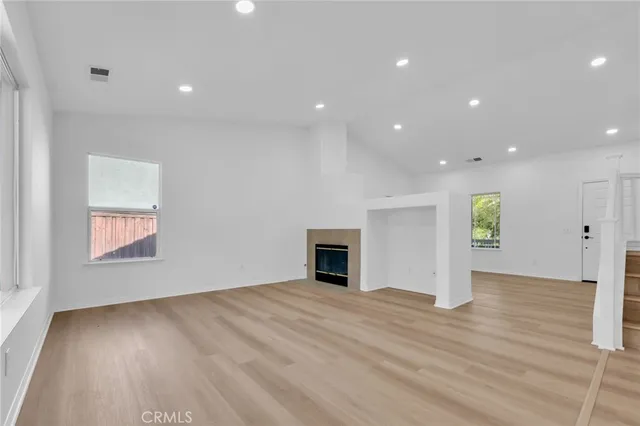 a view of empty room with wooden floor and fireplace