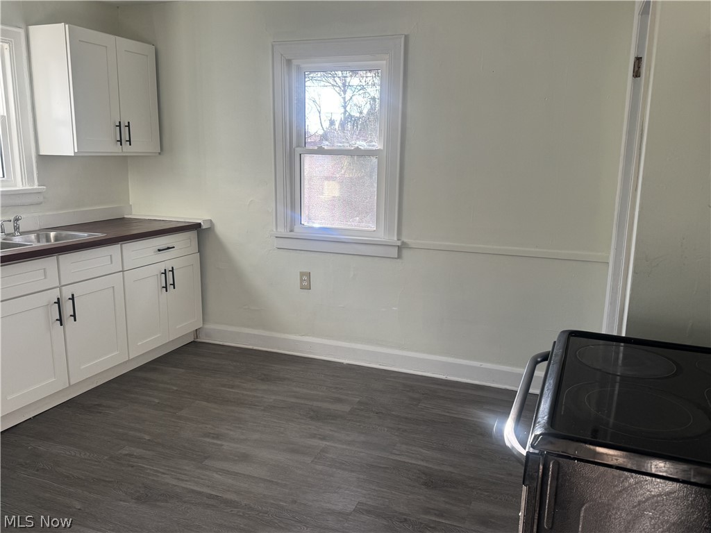 4058 Ardmore Road Cleveland, OH 44121 - Photo 8 of 14 Kitchen with electric range, white cabinets, dark wood finished floors, and wood counters
