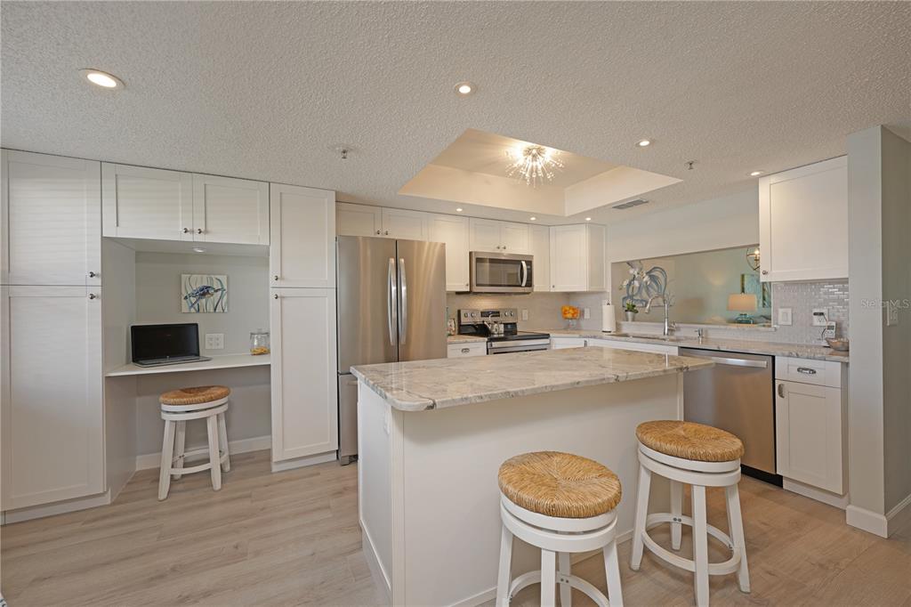 6501 Stone River Road, Unit 205 Bradenton, FL 34203 - Photo 14 of 50 a kitchen with kitchen island a stove a table and chairs