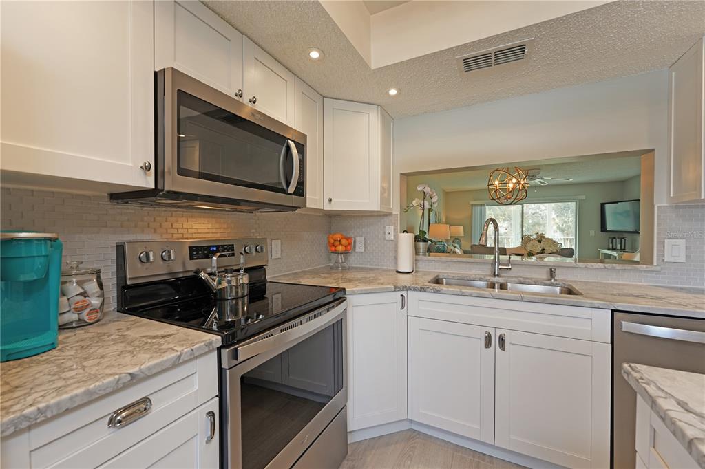 6501 Stone River Road, Unit 205 Bradenton, FL 34203 - Photo 15 of 50 a kitchen with a sink stove and microwave