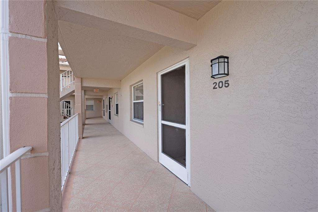 6501 Stone River Road, Unit 205 Bradenton, FL 34203 - Photo 4 of 50 a hallway with white cabinets and refrigerator