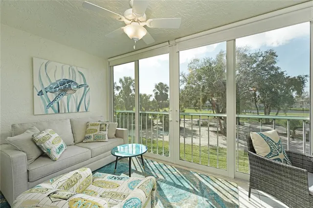 a living room with furniture a flat screen tv and a large window