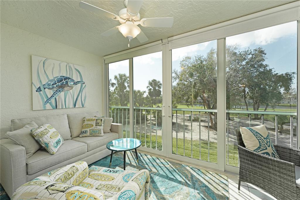 6501 Stone River Road, Unit 205 Bradenton, FL 34203 - Photo 5 of 50 a living room with furniture and a floor to ceiling window