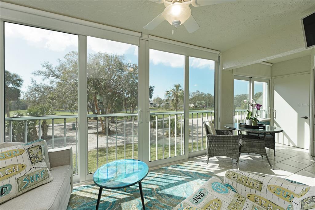 6501 Stone River Road, Unit 205 Bradenton, FL 34203 - Photo 6 of 50 a living room with furniture and a floor to ceiling window
