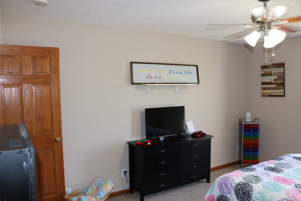 410 Pine White Road, Unit 1 Roscoe, IL 61073 - Photo 11 of 13 a bedroom with a bed and a television