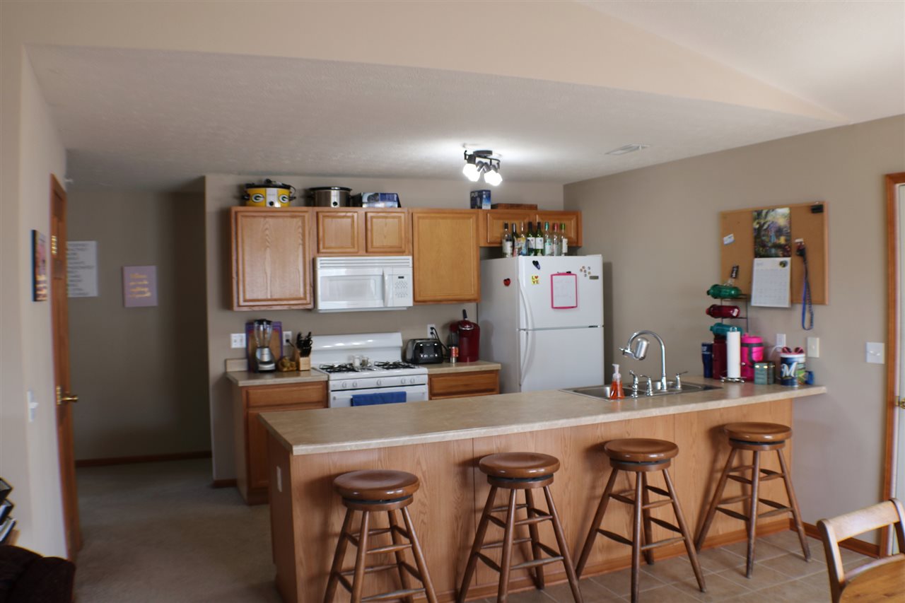 410 Pine White Road, Unit 1 Roscoe, IL 61073 - Photo 5 of 13 a kitchen with stainless steel appliances a white table and chairs in it