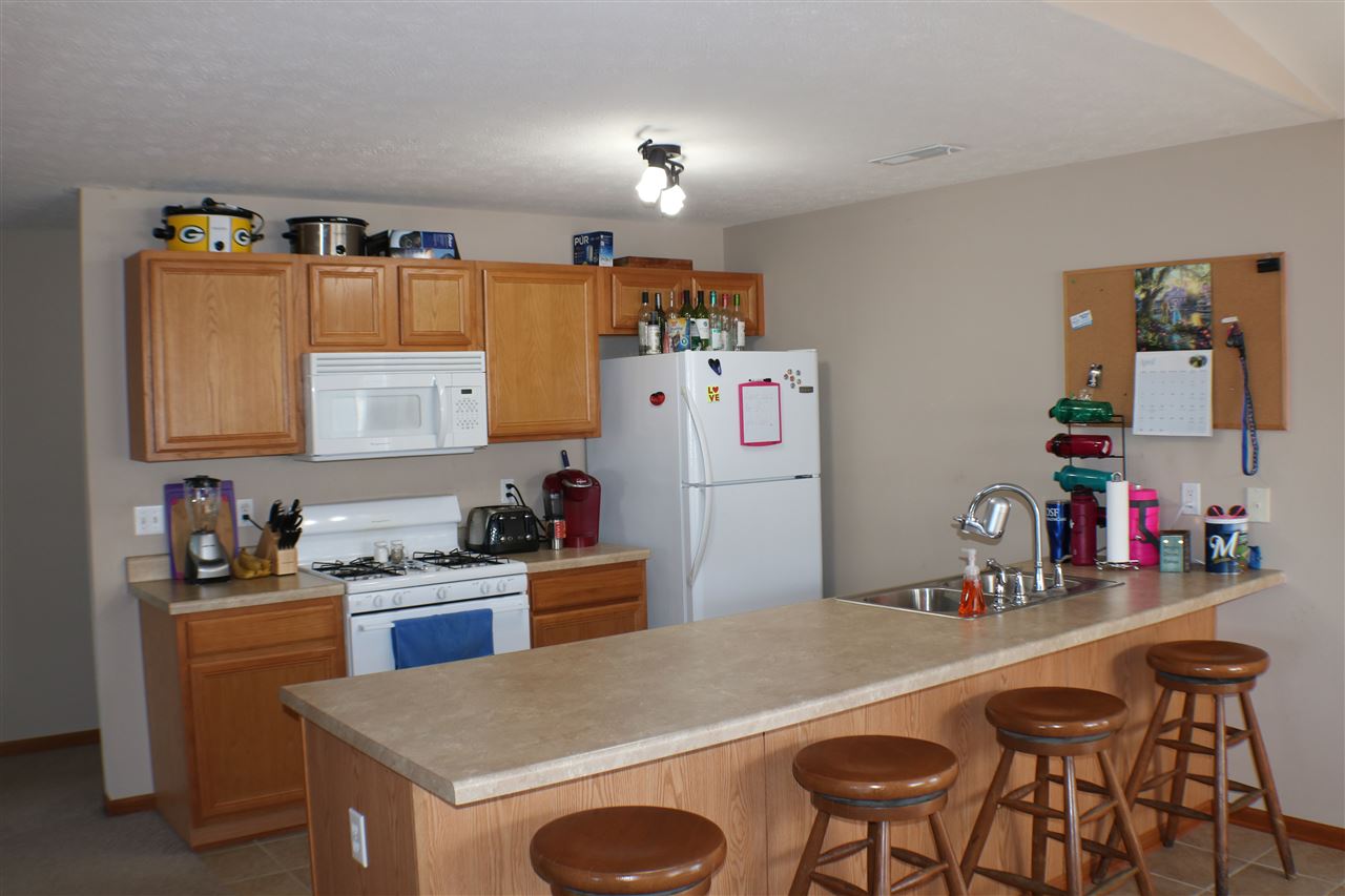410 Pine White Road, Unit 1 Roscoe, IL 61073 - Photo 8 of 13 a kitchen with granite countertop a sink a stove and refrigerator