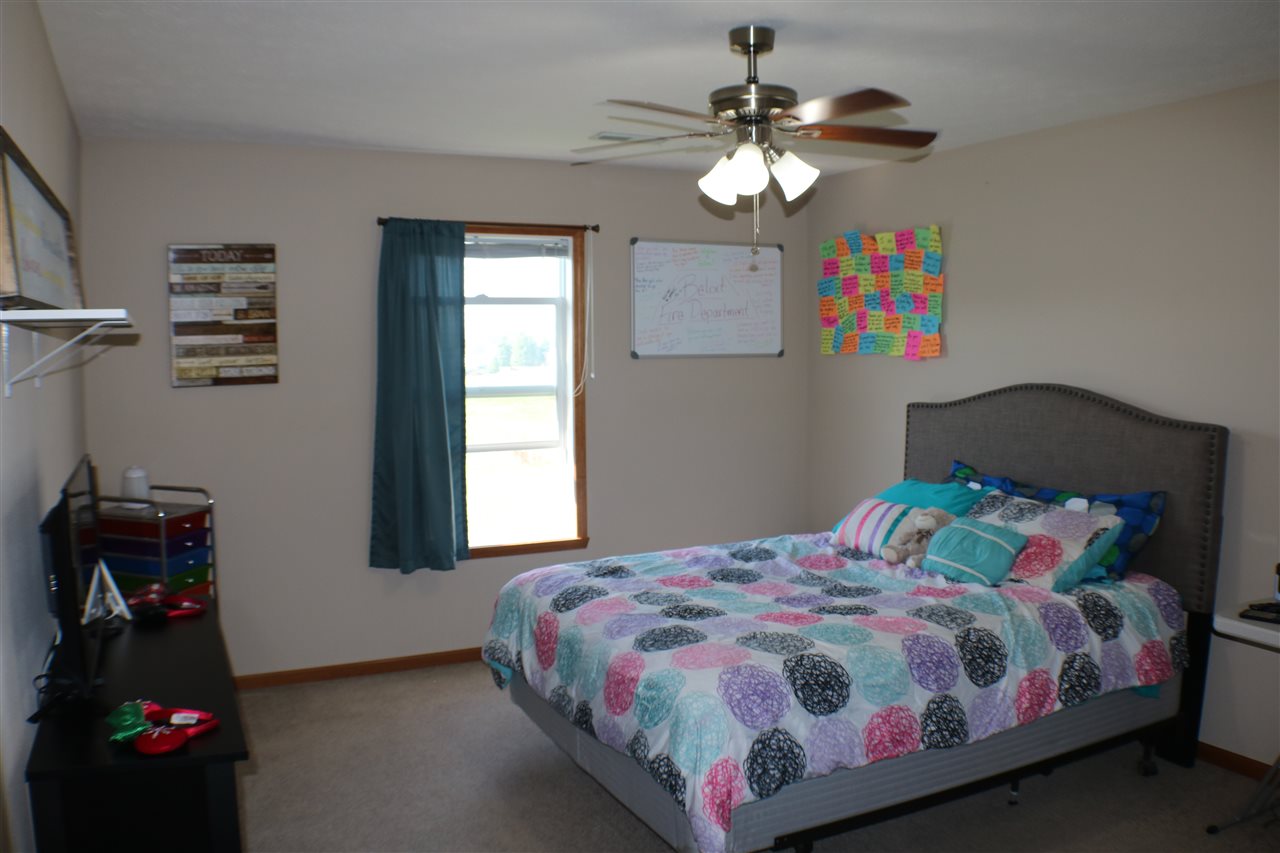 410 Pine White Road, Unit 1 Roscoe, IL 61073 - Photo 9 of 13 a bedroom with a bed and a chandelier
