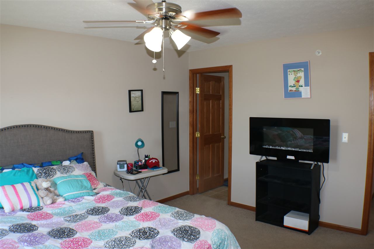 410 Pine White Road, Unit 1 Roscoe, IL 61073 - Photo 10 of 13 a bedroom with a bed and a flat tv screen on dresser