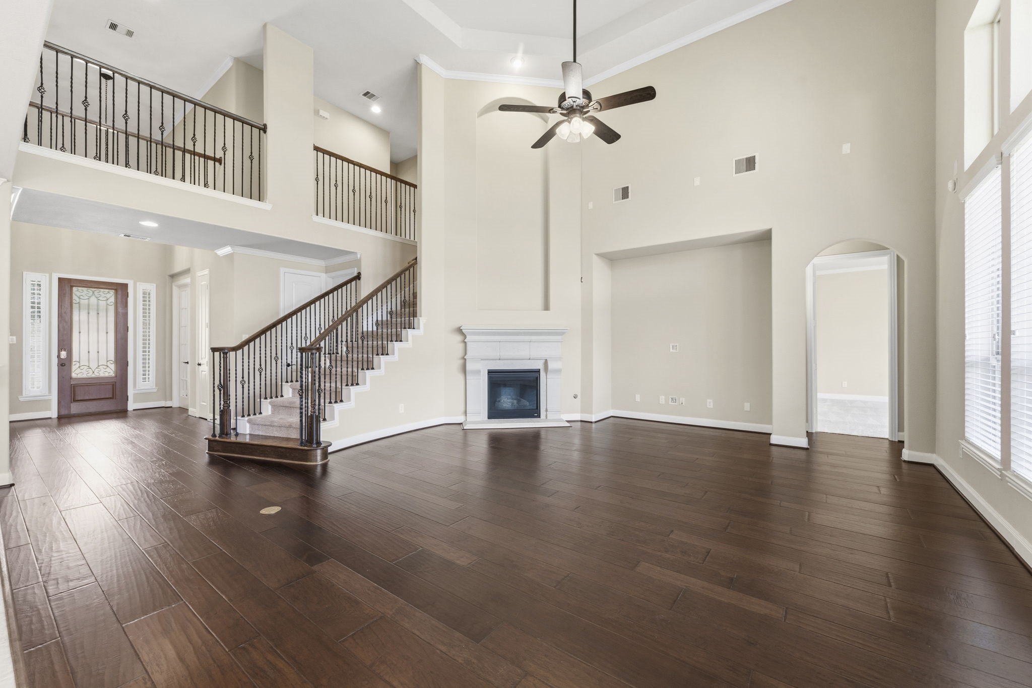 25210 Gaddis Oaks Drive Spring, TX 77389 - Photo 16 of 50 an empty room with wooden floor staircase and a window