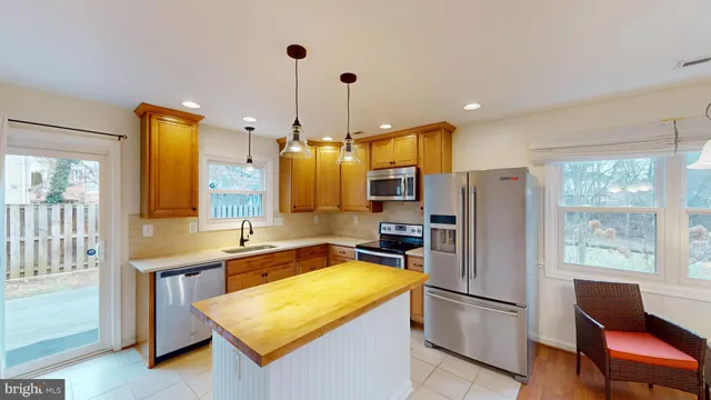 a kitchen with refrigerator a sink and chairs