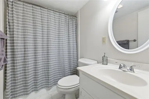 a bathroom with a toilet a sink and mirror