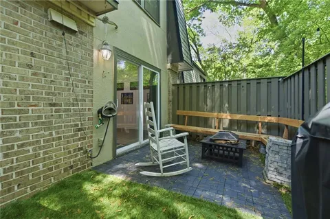 a view of a chair and table in the back yard of the house