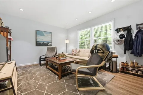 a living room with furniture a flat screen tv and a floor to ceiling window