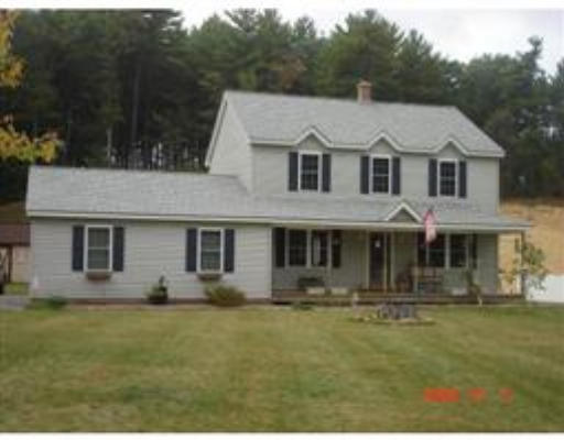 86 Walkeen Koziol Road Warren, MA 01083 - Photo 1 of 11 a view of a white house with large windows and a small yard