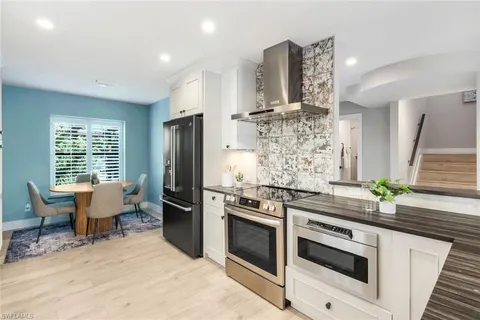 a kitchen with stainless steel appliances kitchen island granite countertop a stove and a refrigerator