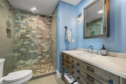 a bathroom with a sink a toilet and shower