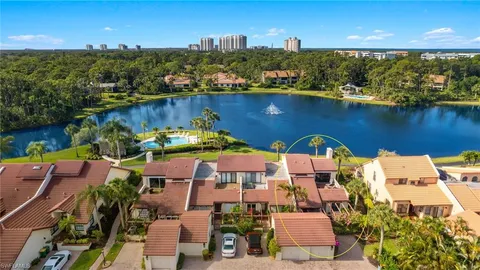 an aerial view of residential houses with outdoor space and lake view