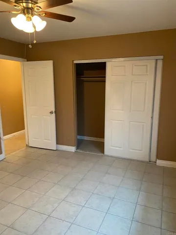 an empty room with chandelier fan