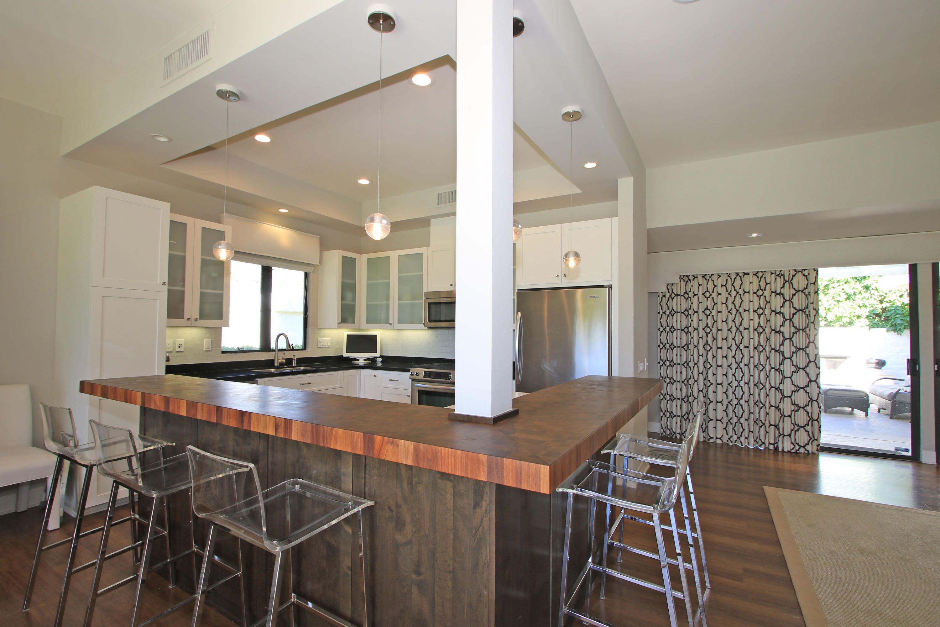 45760 Pawnee Road Indian Wells, CA 92210 - Photo 17 of 56 a kitchen with stainless steel appliances granite countertop table chairs and wooden floor