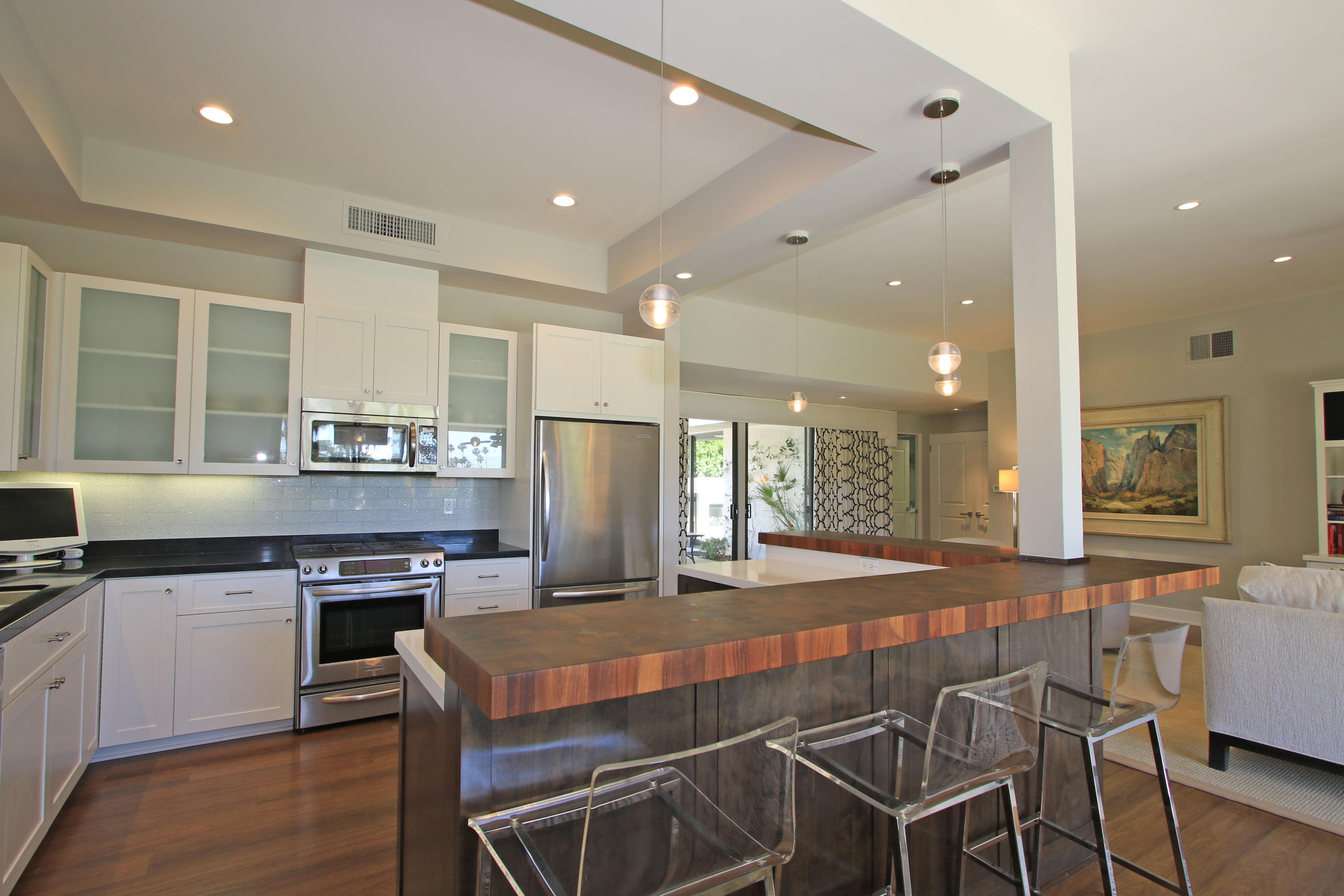 45760 Pawnee Road Indian Wells, CA 92210 - Photo 20 of 56 a kitchen with stainless steel appliances a dining table chairs stove refrigerator and cabinets